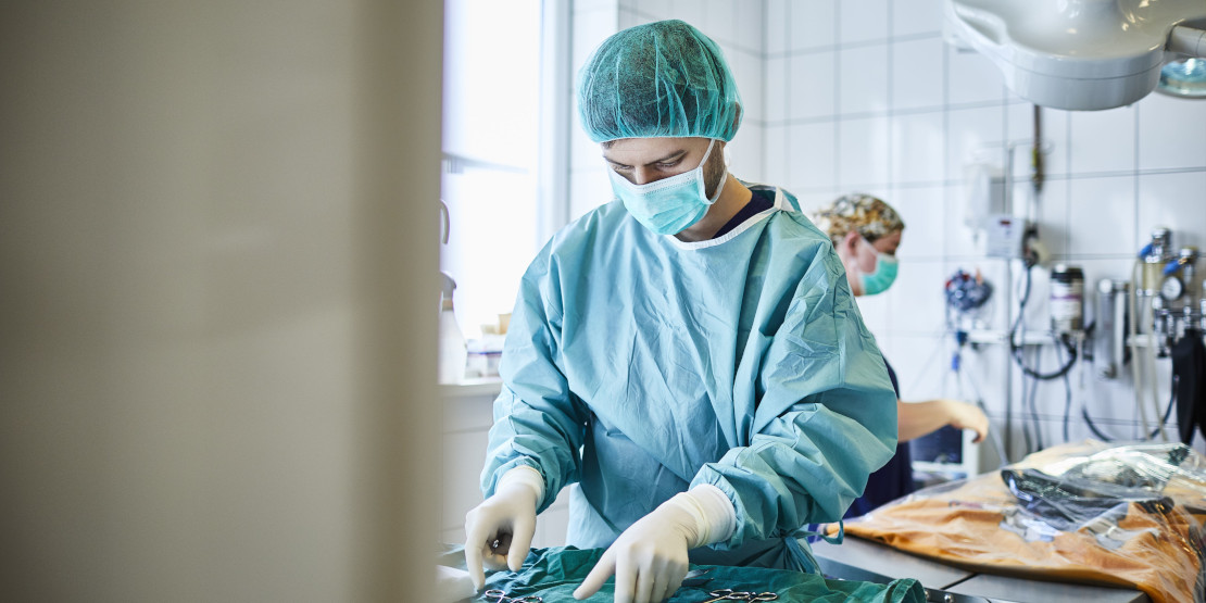 Medizinstudent in OP-kleidung legt sich seine Instrumente bereit.