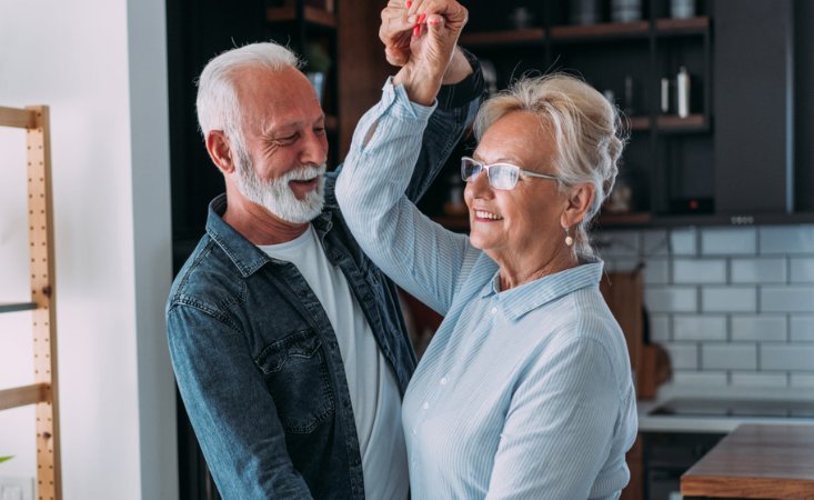 Ein älteres Ehepaar tanzt in der Küche.