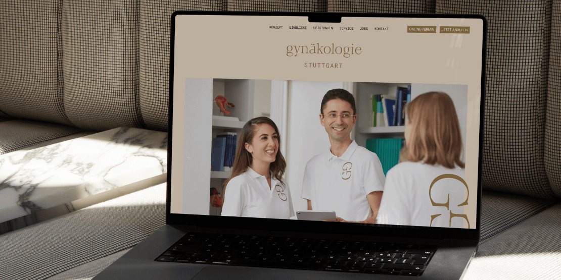 Ein Notebook steht aufgeklappt auf einem Sofa. Der Monitor zeigt eine Website