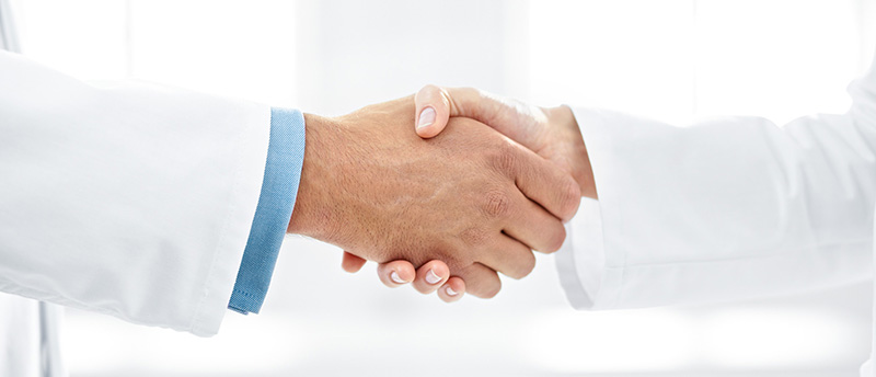 Gehalt als Facharzt: Zwei Ärzte schütteln sich die Hand.